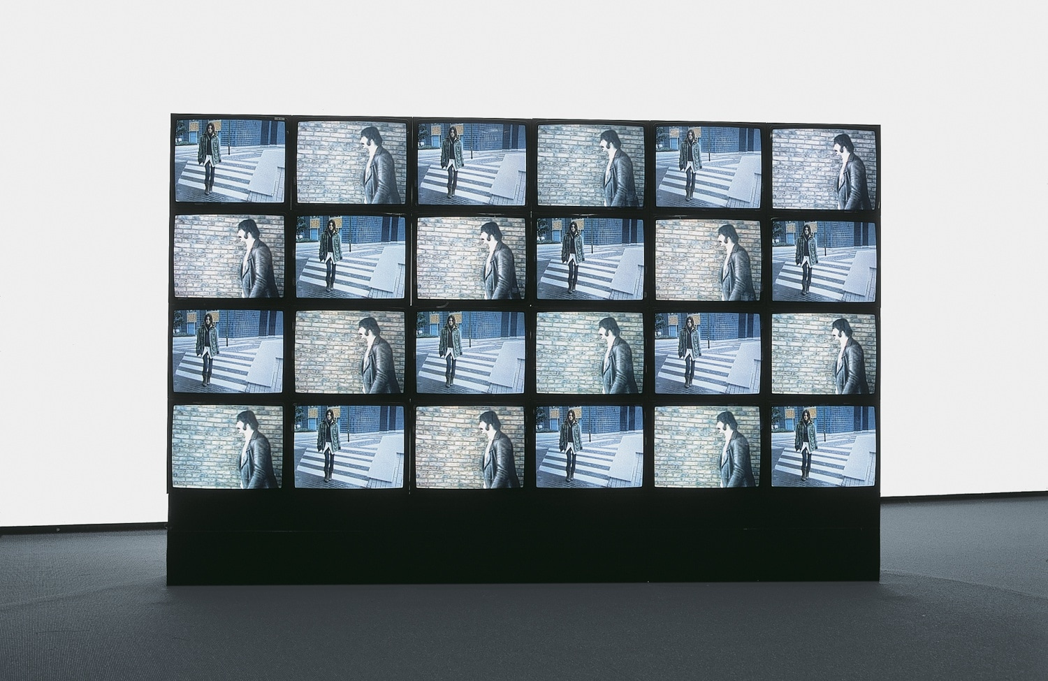 clockwork for oracles, 2004 (detail) 3 videowalls, 3 stencilled burlaps, 3 wooden bases, sound, carpet 354 cm × 233 cm...