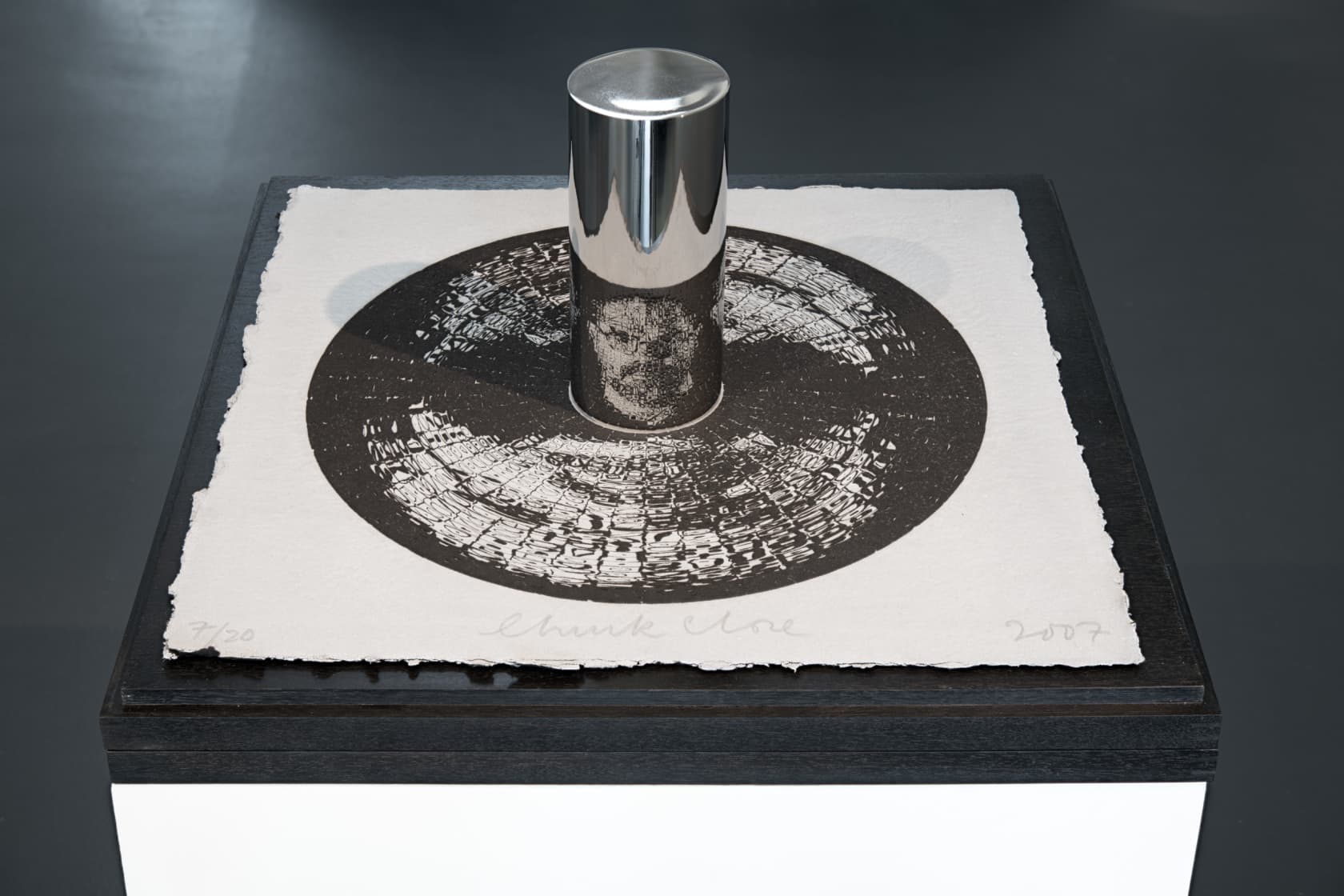 Chuck Close Self-Portrait (anamorphic) Engraving with embossment on black Twinrocker handmade paper, polished stainless steel cylinder, and wooden platform