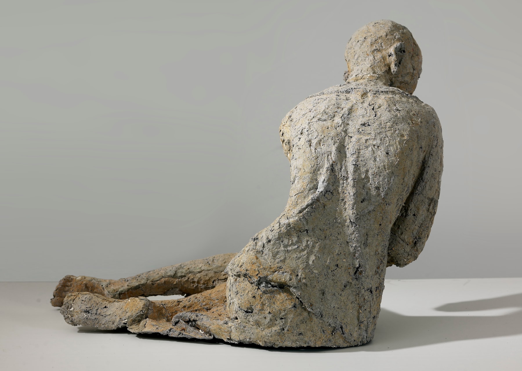 The back of a reclining woman who is made of paper mache.