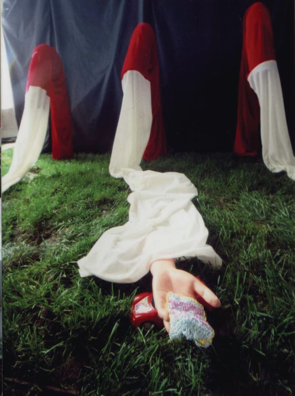 A closer shot of one of red-and-white long sleeves; a piece of fabric is placed on the center of the palm of the artificial arm.