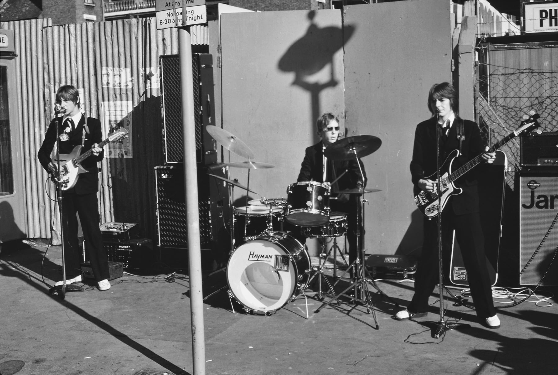 Caroline Coon, The Jam. Paul Weller (guitar), Rick Buckler (drums) and Bruce Foxton (bass) performing a pop-up gig on the Soho street., 1976
