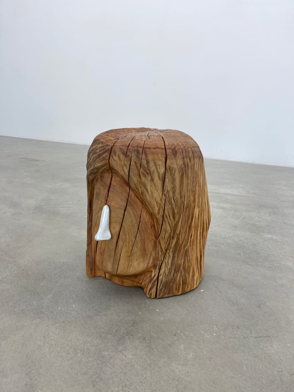 wooden stool shaped into a head with metal nose