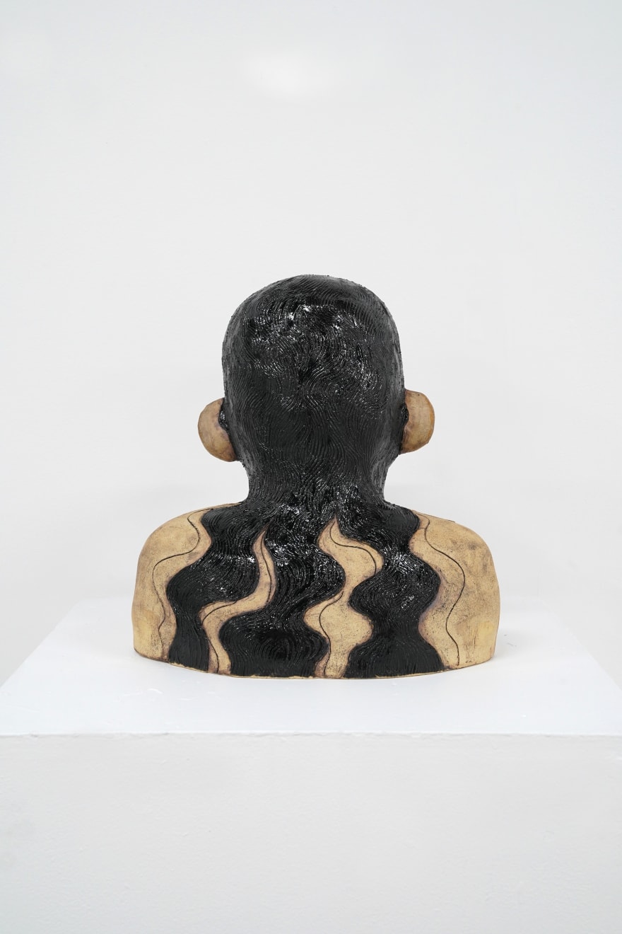 ceramic bust of a person with long hair and horns