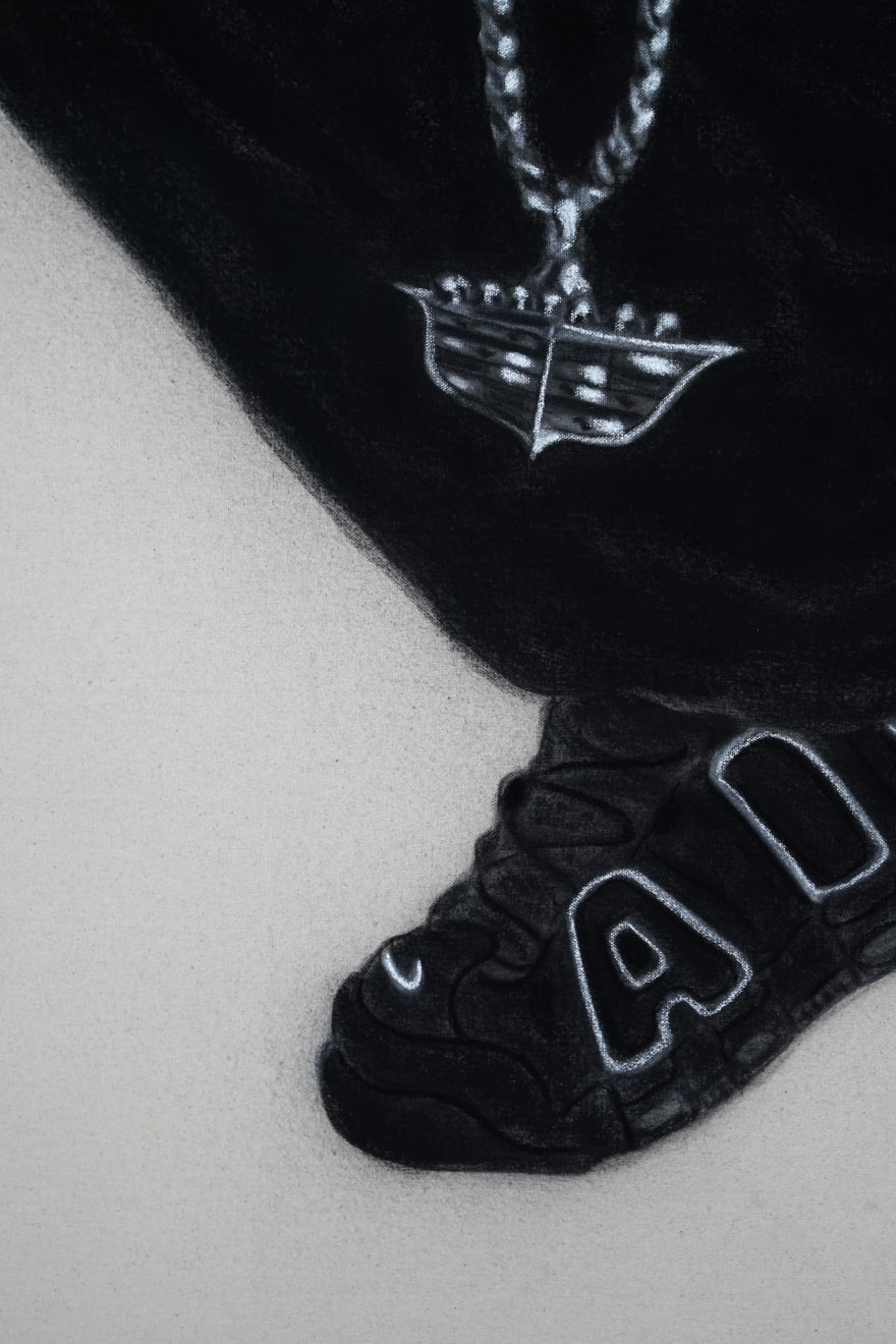 charcoal drawing of a man crouching wearing air jordans and a cadillac symbol necklace