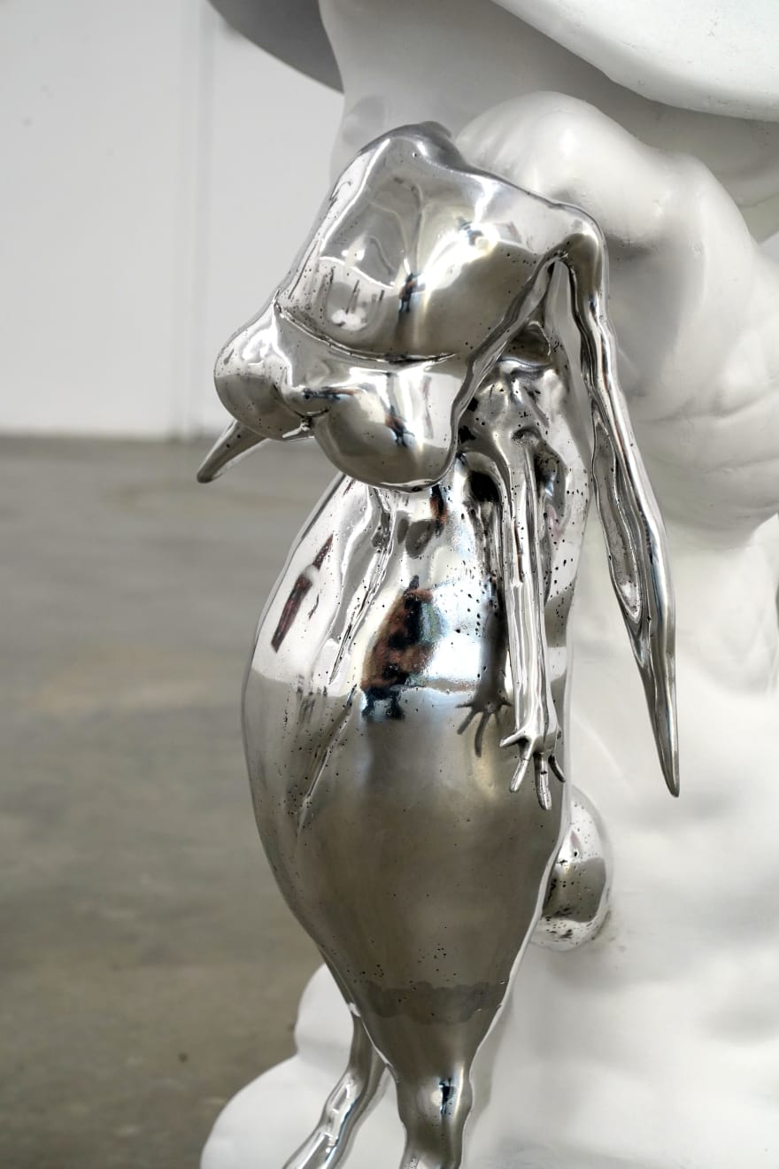 sculpture of a child wearing a hat and holding a bunny