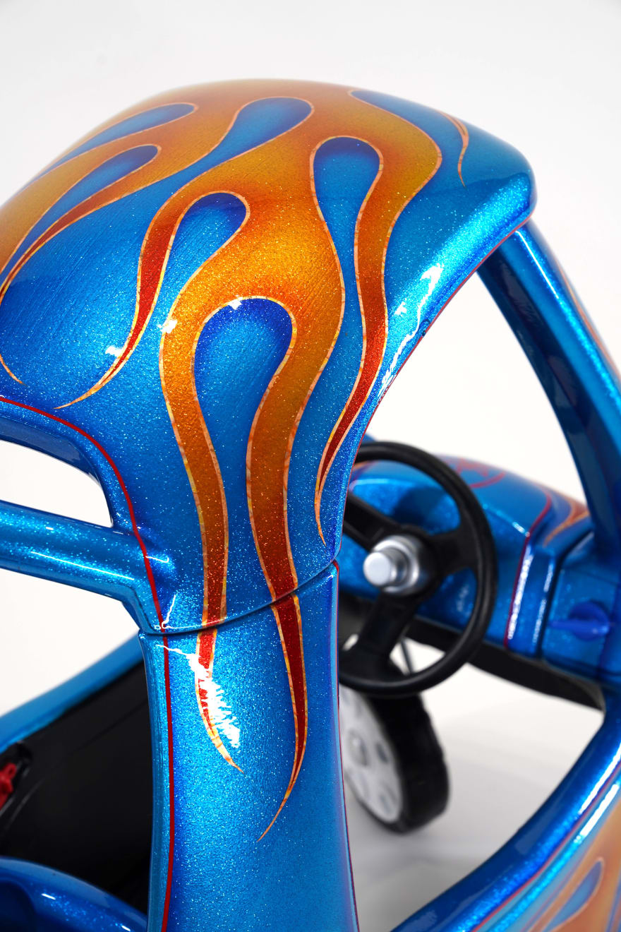 photo of a blue childrens car with painted flames