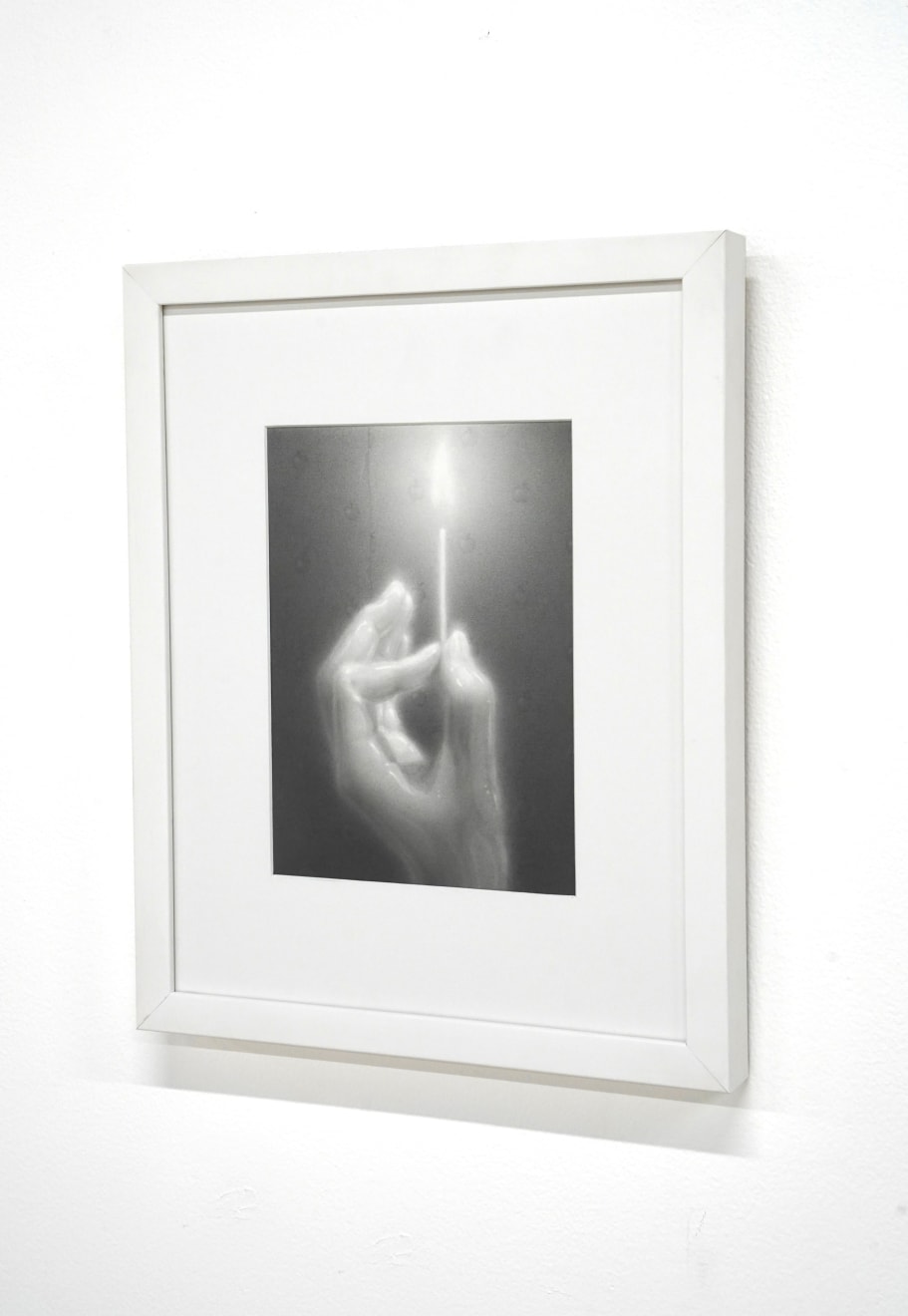 black and white charcoal hand holding a lit match, framed in white