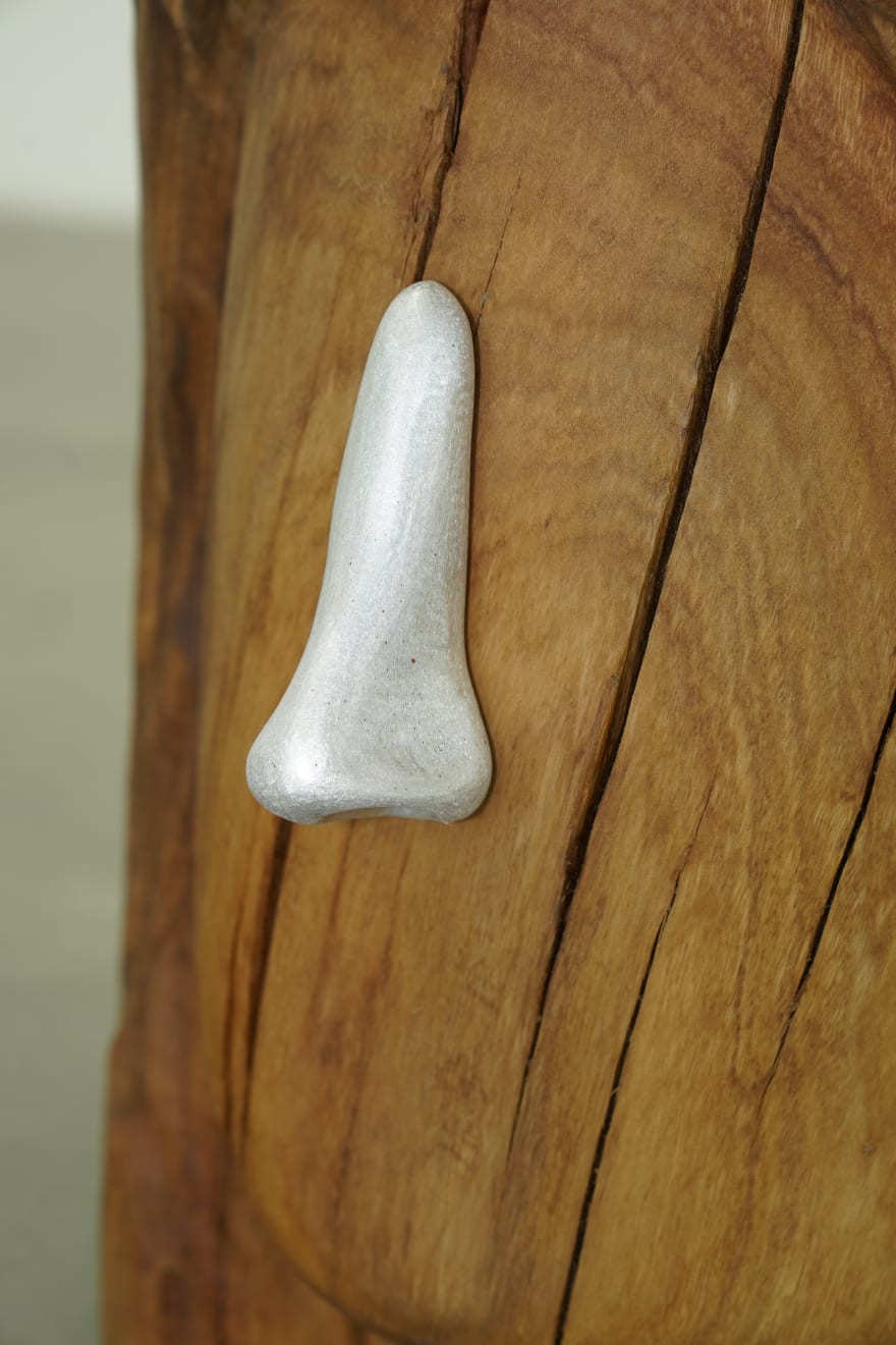 wooden stool shaped into a head with metal nose