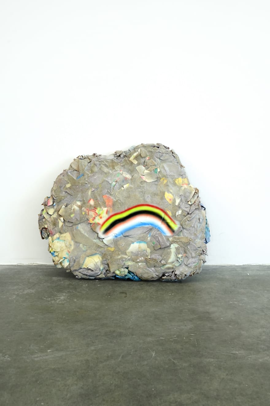 rock sculpture with frown face (rainbow)
