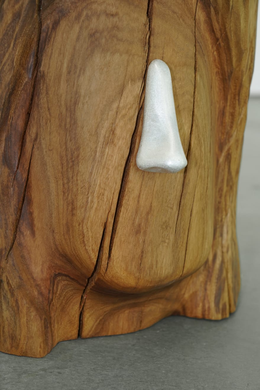 wooden stool shaped into a head with metal nose