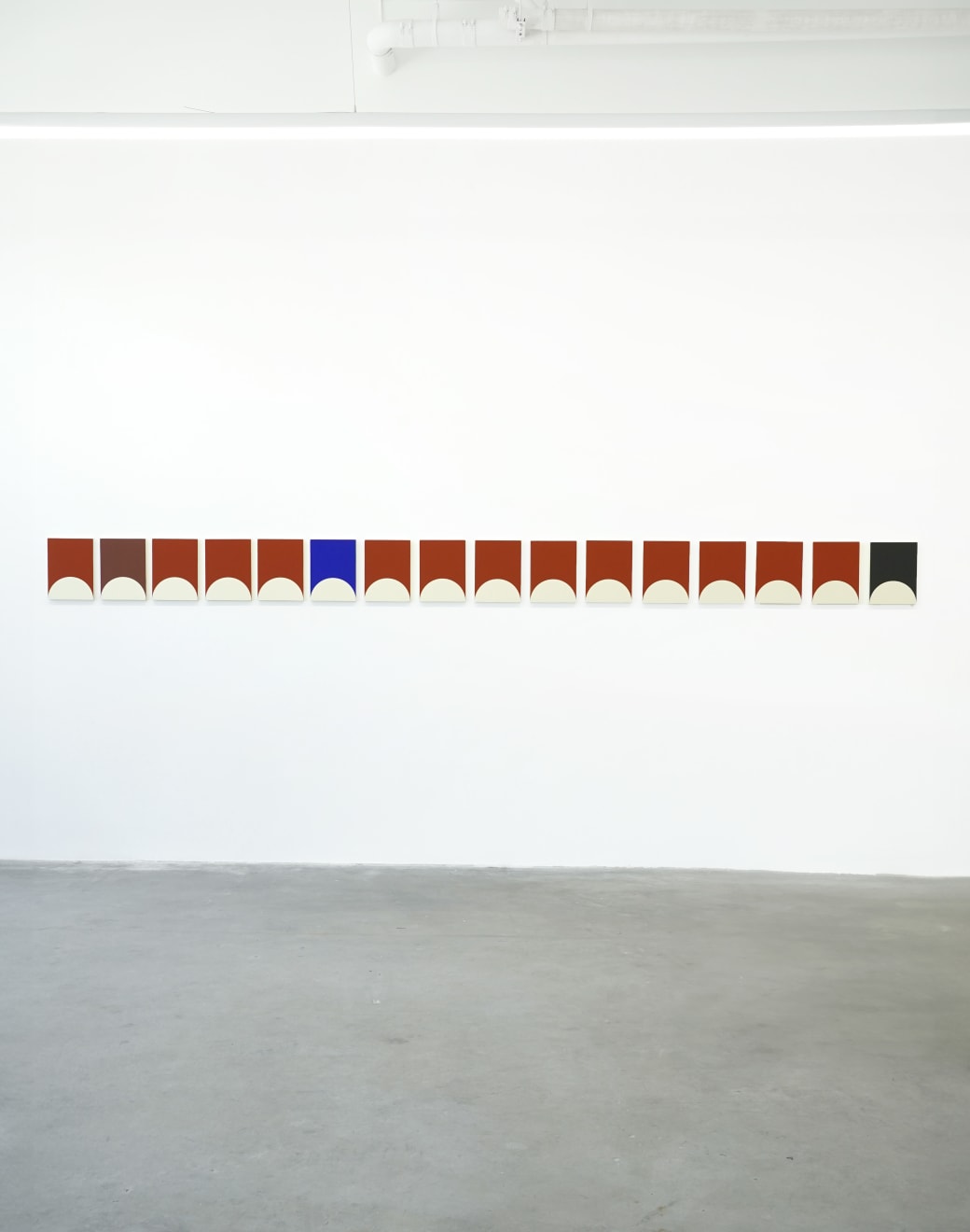 array of of geometrically painted paintings hung in a straight line