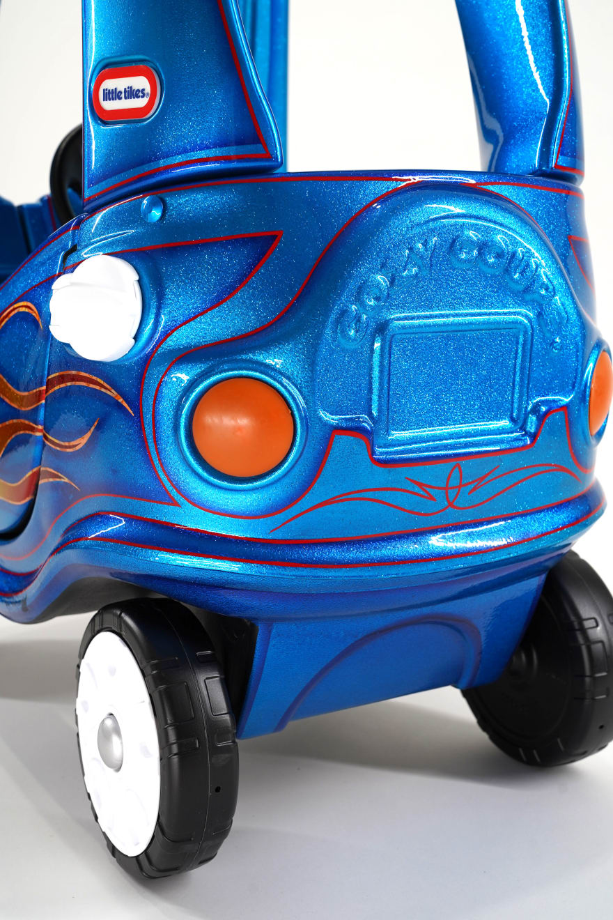 photo of a blue childrens car with painted flames