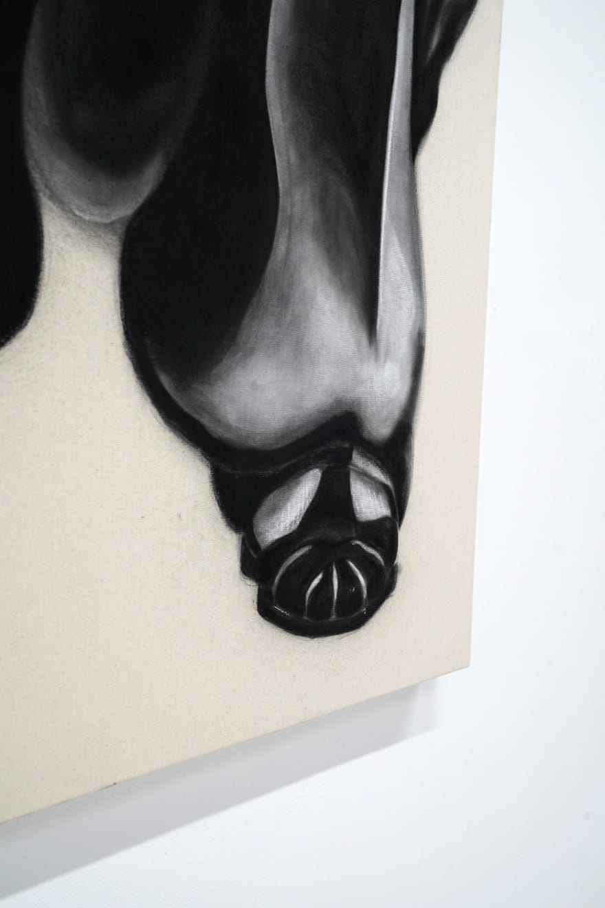 black and white charcoal drawing of a man crouching with baggy jeans