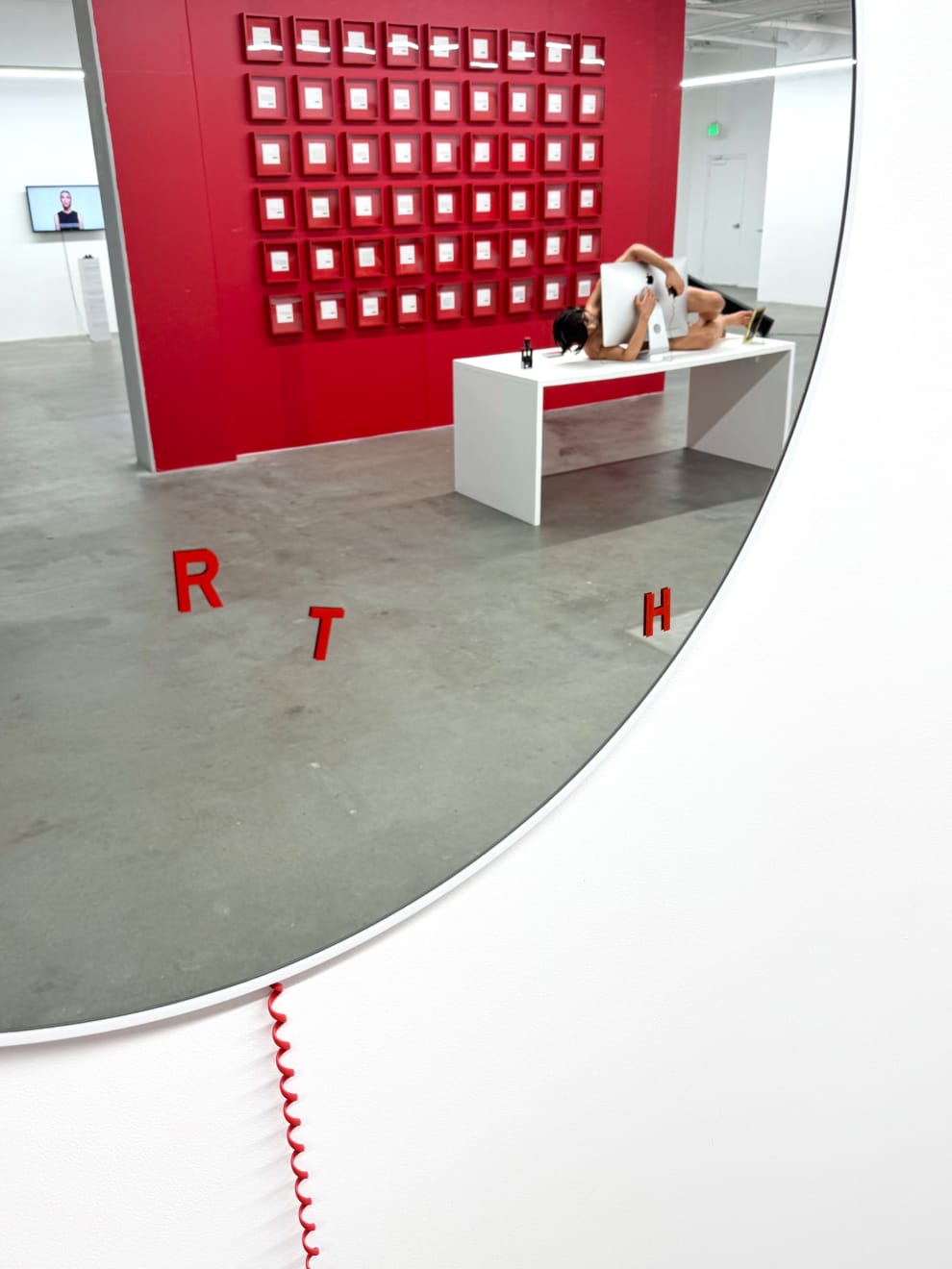circular mirror with a red phone hanging from it