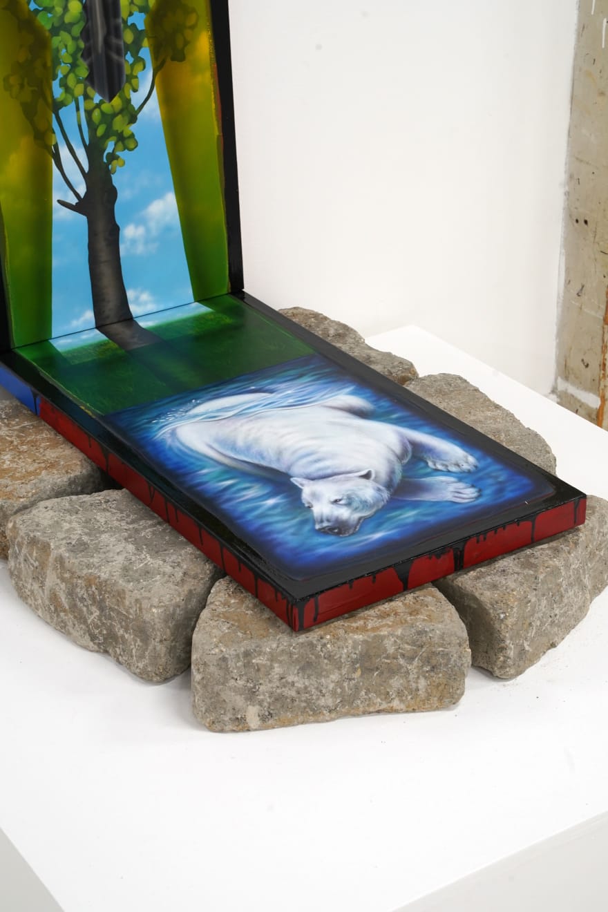 triptych painting positioned on top of a bed of rocks by Mia Scarpa. The artwork represents the tree of life