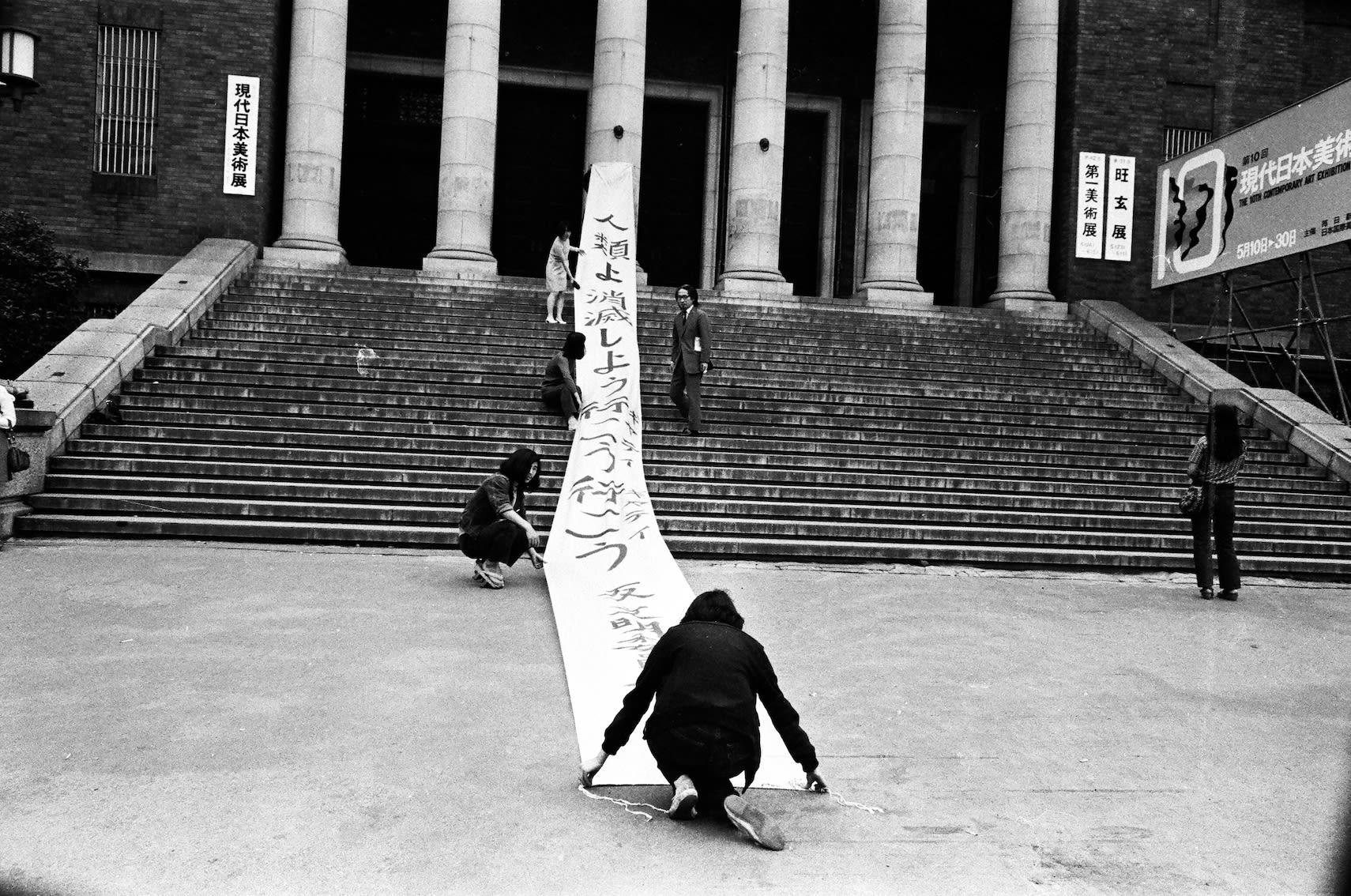 Mitsutoshi Hanaga, Matsuzawa Yutaka Performing with “Banner of Vanishing” (Humans, Let's Go, Let's Go, Gate, Gate—Anti-Civilization Committee)" (1966) at The 10th Contemporary Art Exhibition of Japan at Tokyo Metropolitan Art Museum, May 1971, 1971