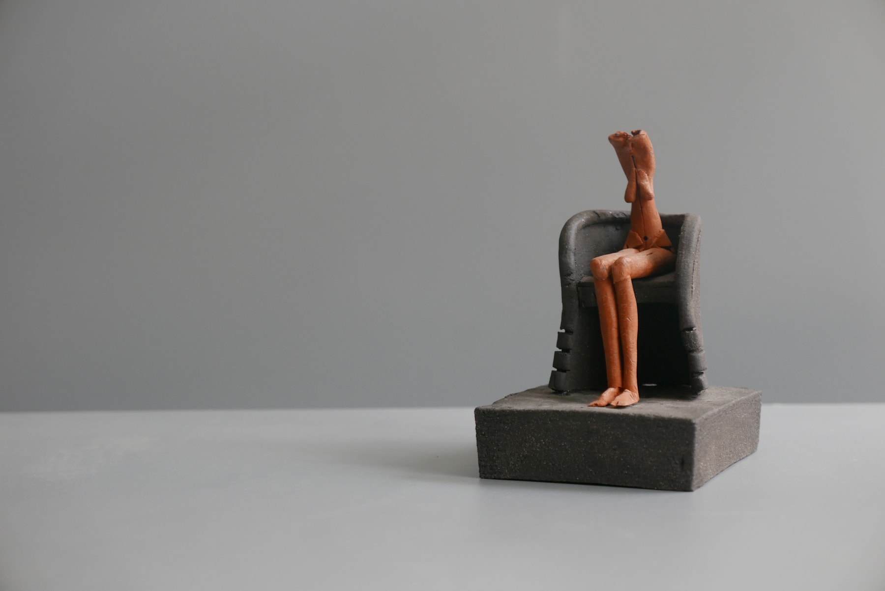 Mo Jupp, Terracotta Figure Seated in a Black Armchair