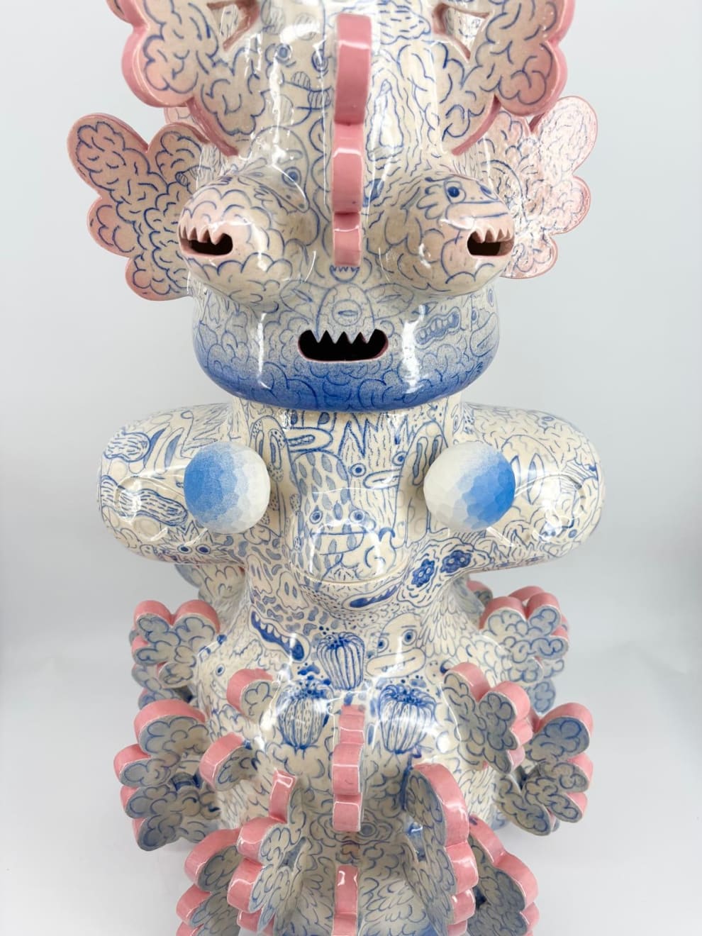 Close-up of biomorphic ceramic sculpture “Tattooed Space Monkey” (2025) by Kartini Thomas, showing pink-edged protrusions and fine blue motifs on glazed surface.