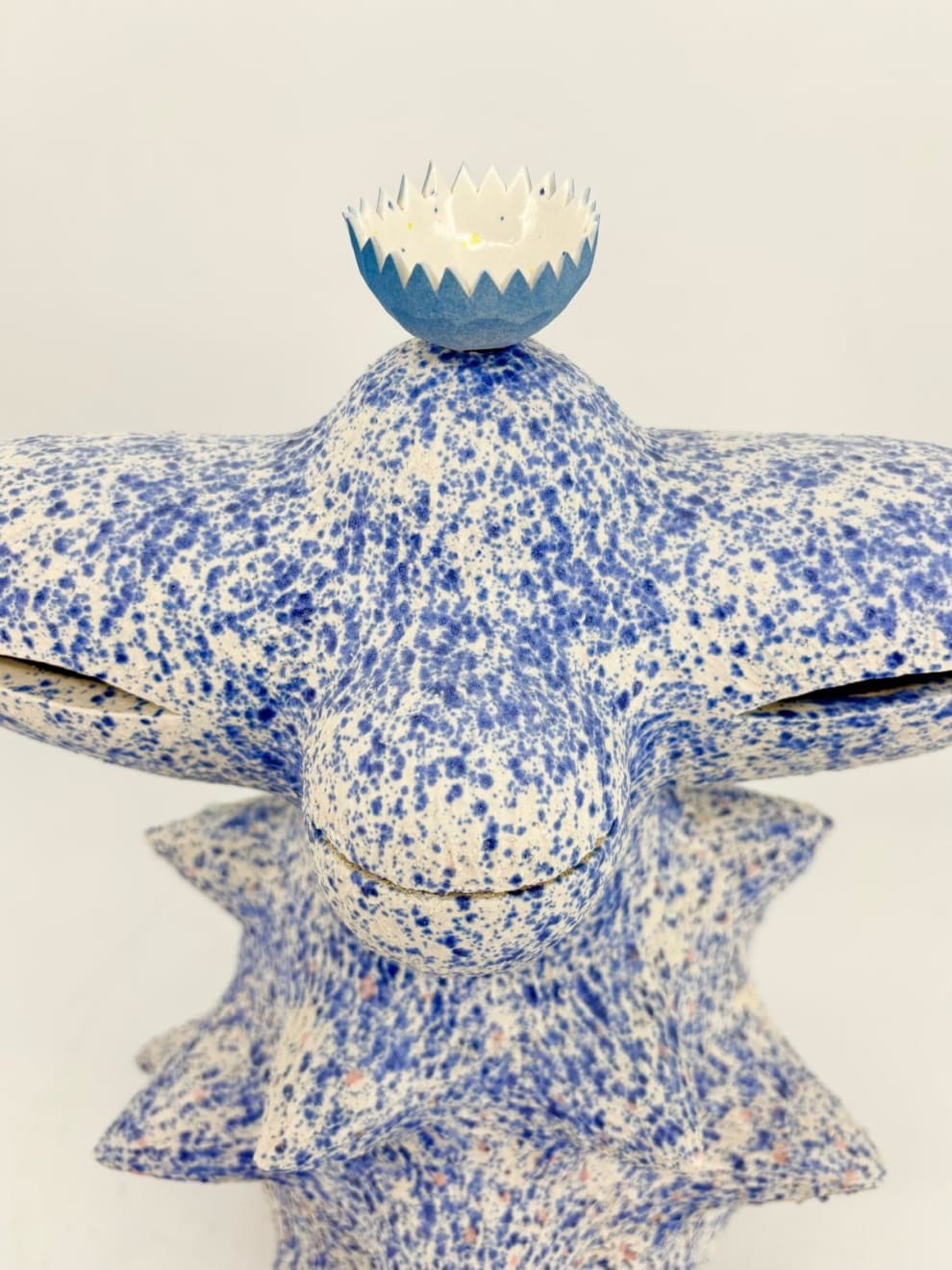 Detail of Kartini Thomas’s ceramic sculpture showing the porcelain lotus bowl atop a speckled blue form