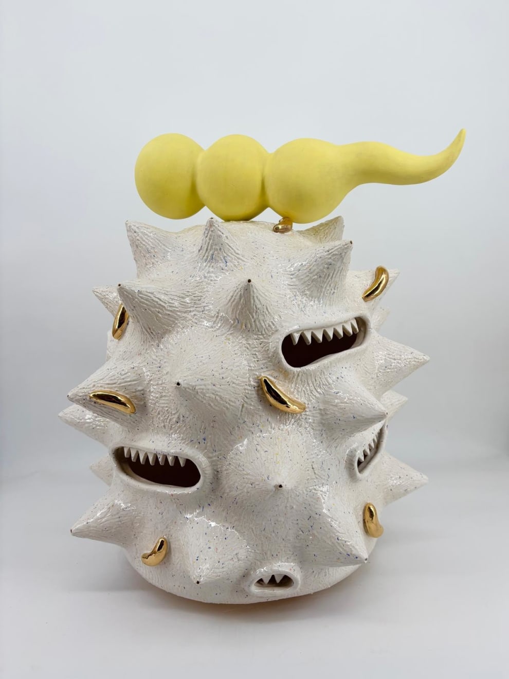 Kartini Thomas ceramic sculpture “Fat white spooter” with white spikes, yellow horn, and gold luster details