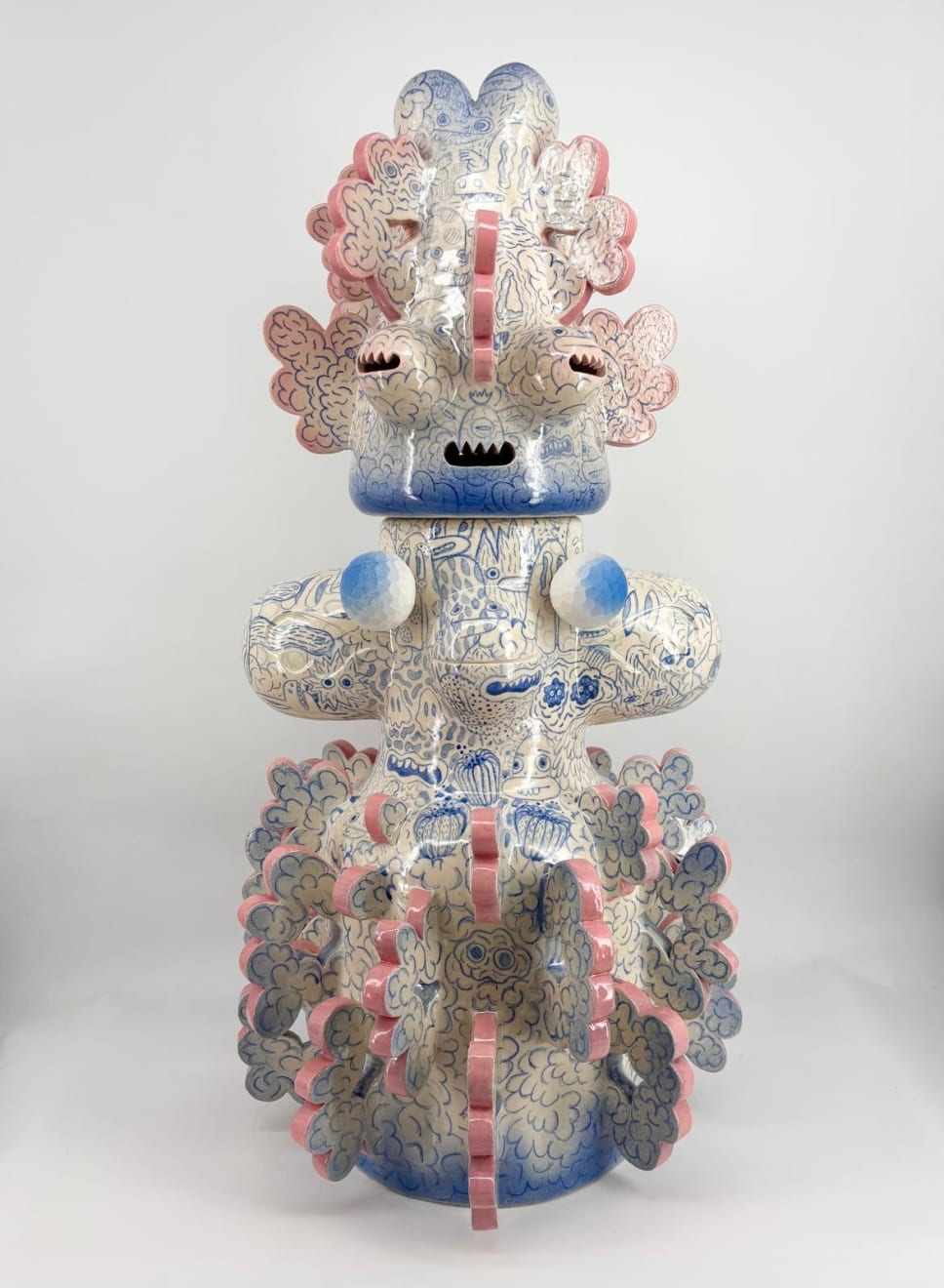 Back view of the ceramic sculpture “Tattooed Space Monkey” (2025) by Kartini Thomas, featuring intricate blue drawings, and pink-edged protuberances.