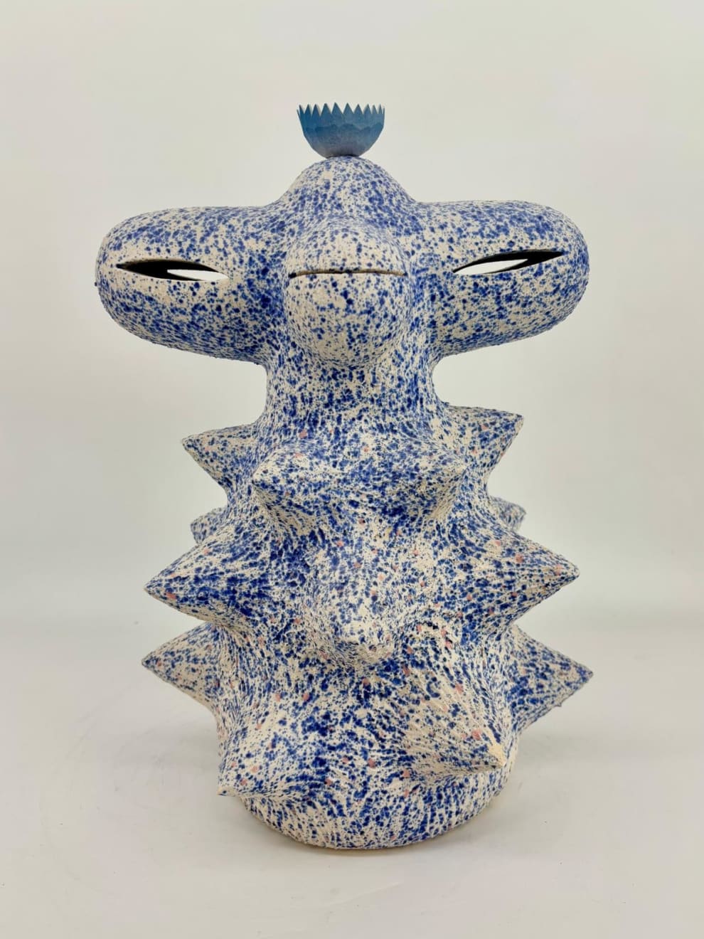 Ceramic sculpture by Kartini Thomas with speckled blue and white surface and porcelain lotus on top