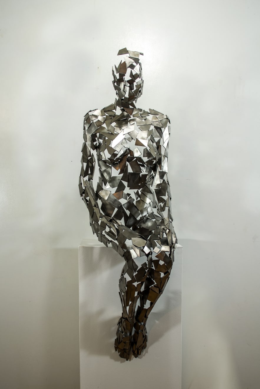 Stainless steel sculpture of a person sitting upright by slate gray gallery artist David Davis