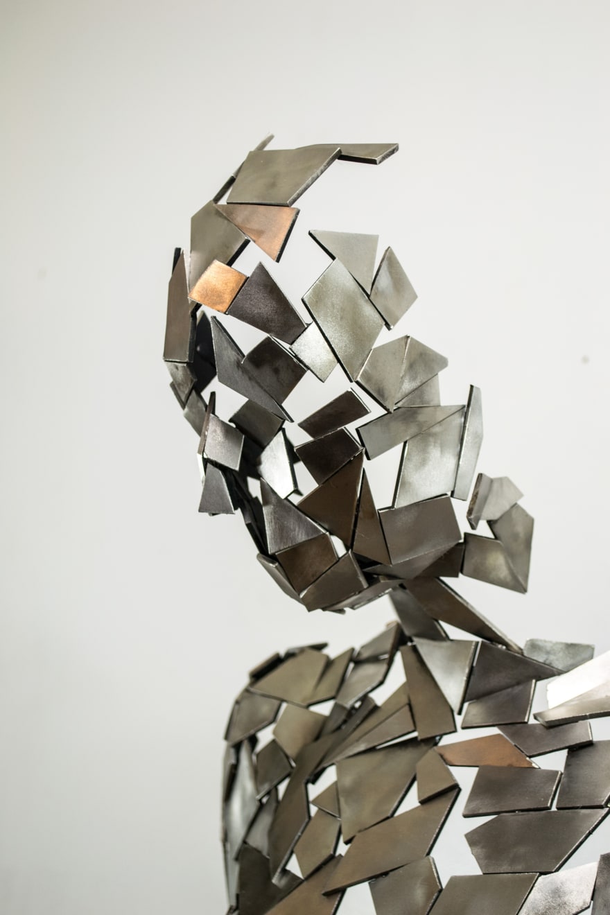 Stainless steel sculpture of a person sitting upright by slate gray gallery artist David Davis