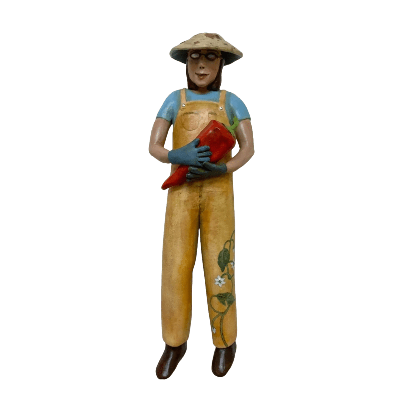 Slate Gray Gallery Artist Julie McNair's clay and oil sculpture of a gardener wearing yellow overalls with a vine on the left leg holding a red pepper titled 