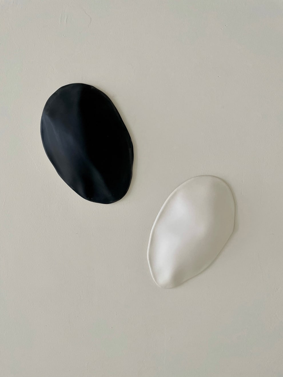 Black and white ceramic petals that can be arranged in multiple ways by slate gray gallery artist Angela Okajima-Kempinas