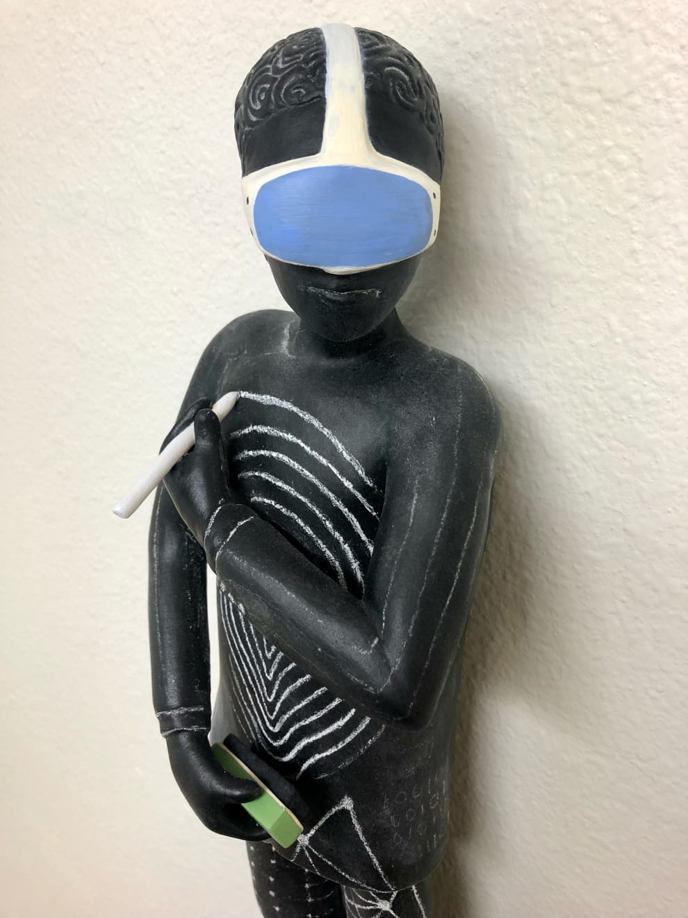Clay with chalkboard paint ceramic sculpture of an alien looking creature with a swirl on its chest by slate gray gallery artist Julie McNair