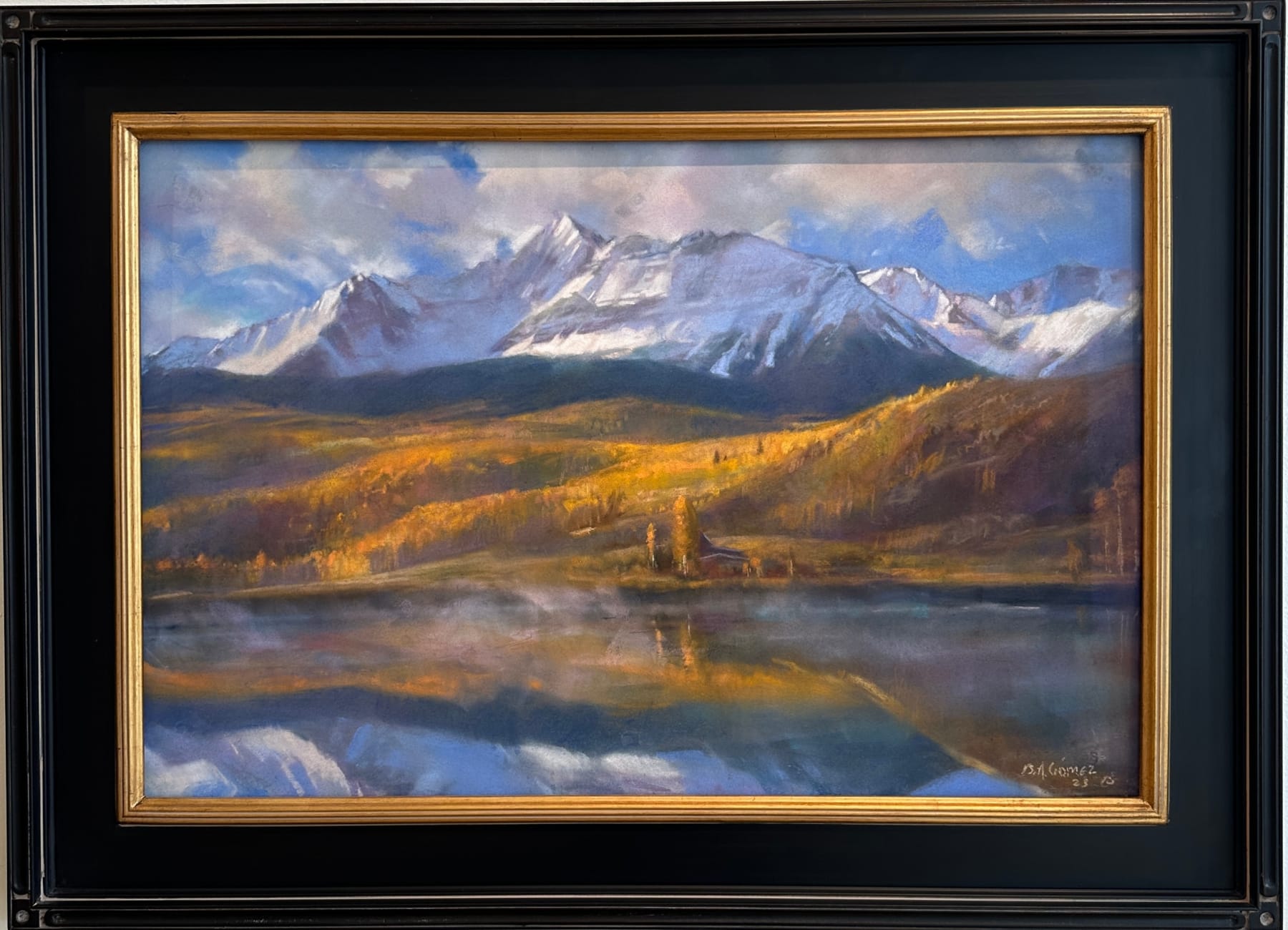 Pastel painting in a black frame of a mountain range with a body of water in front of it by Slate Gray Gallery artist Bruce A. Gomez