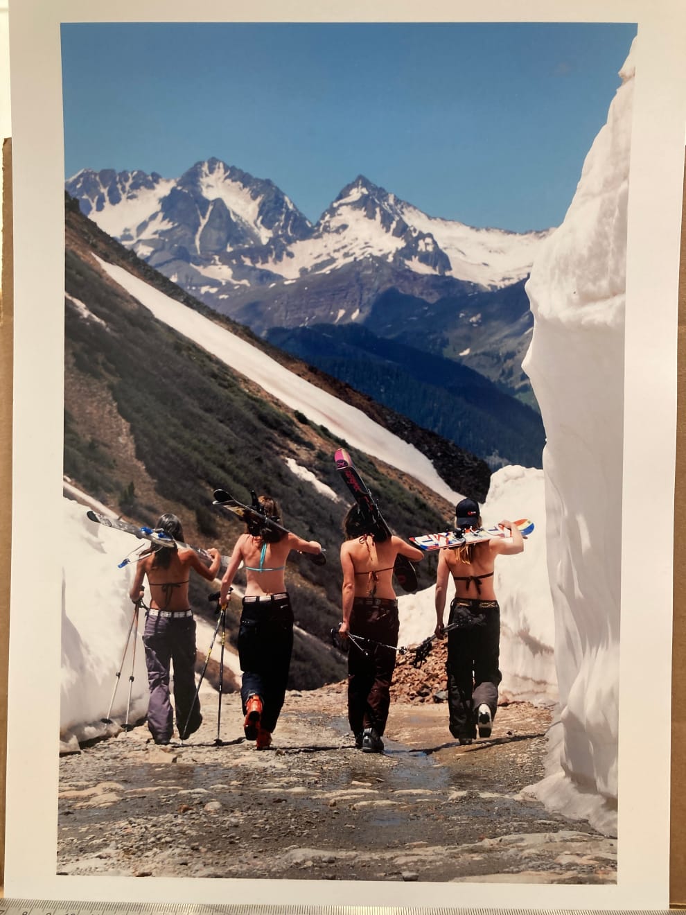 Color photo of four female skiers in bikini tops hiking their skis up ophir pass by slate gray gallery photographer Brett Schreckengost