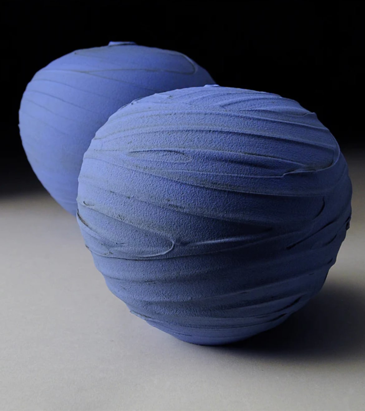 blue textured earthenware vessel with one other blue vessel in the background by potter Nicholas Bernard