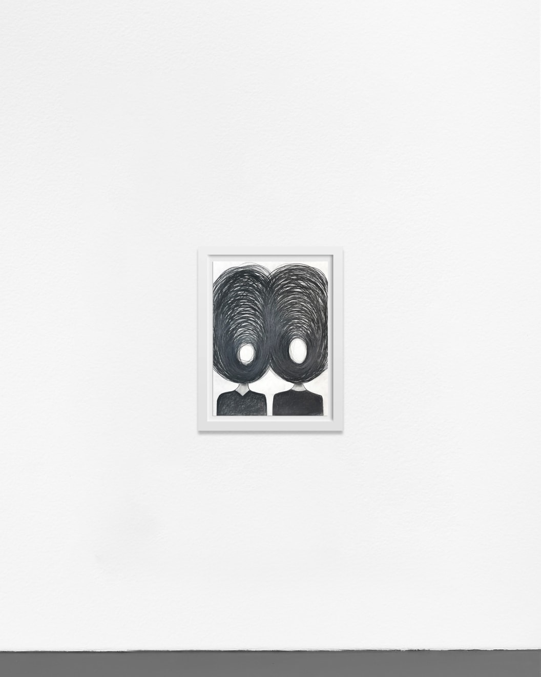 Ted Collier work on paper with two figures and chaotic vicious circle heads in charcoal on white background framed in a white frame hanging on a white wall