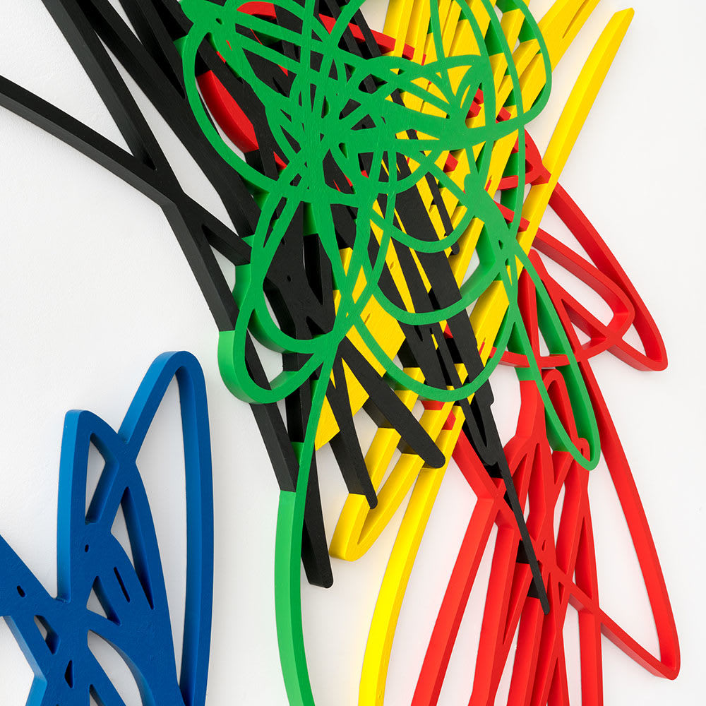 Close up of scribble artwork from Arnaud Vidricaire made of laser cut wood with red blue green black and yellow overlapping colors