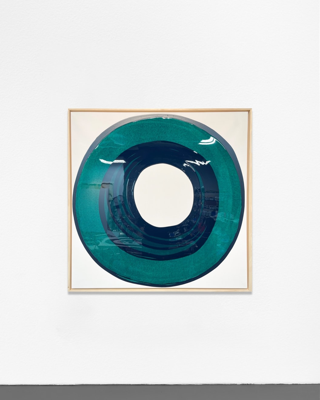 Ted Collier circle series painting with green circle on white canvas hanging on a white wall