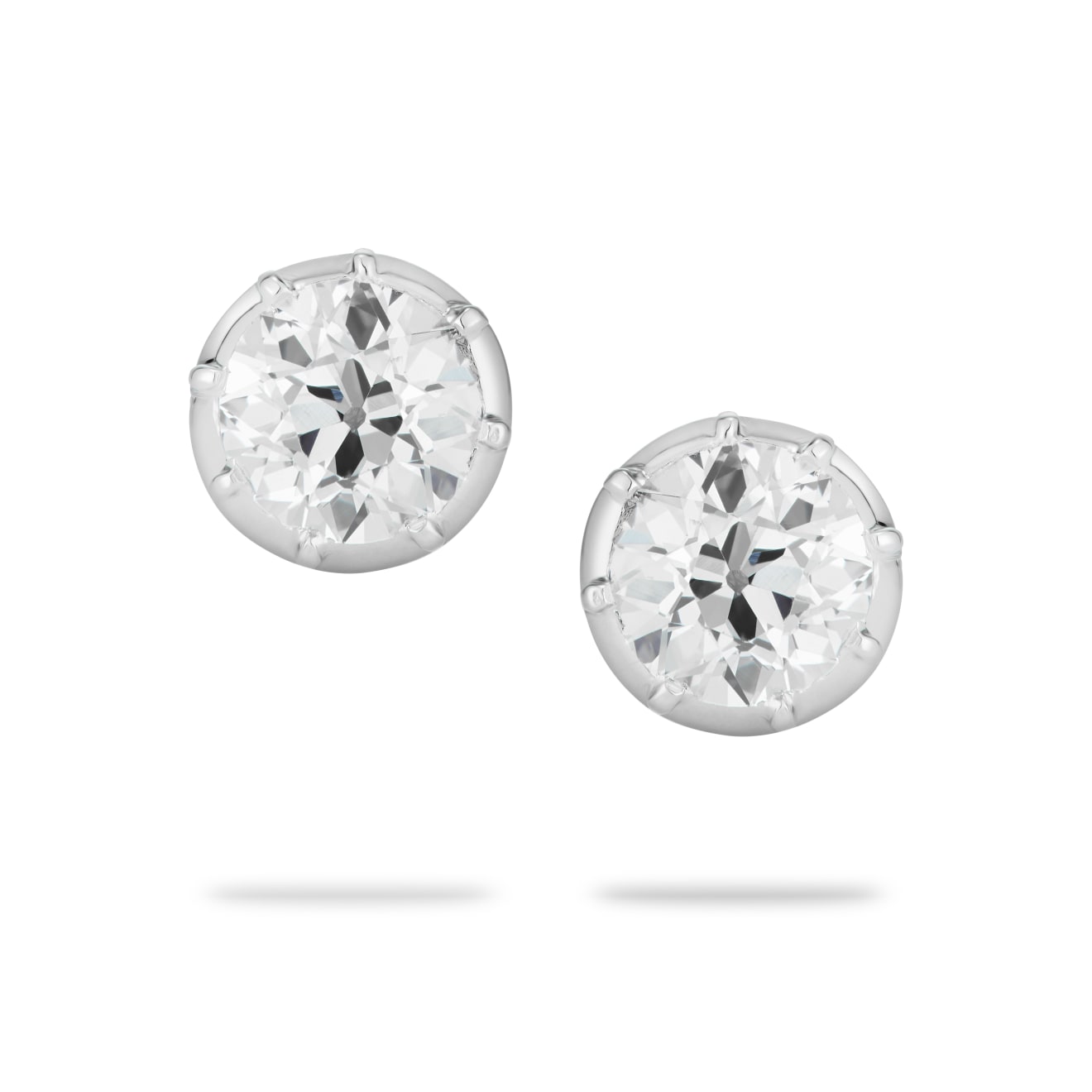 diamond studs set in a cut-down setting of platinum on a white background