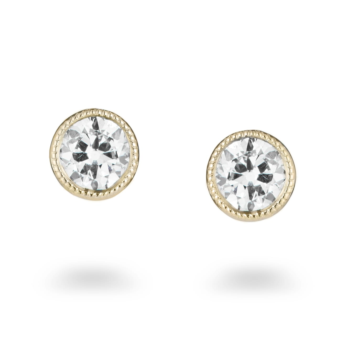 Aril Jewels old-cut diamond studs in rubover millegrain setting of 18ct yellow gold from Clara collection. On white background