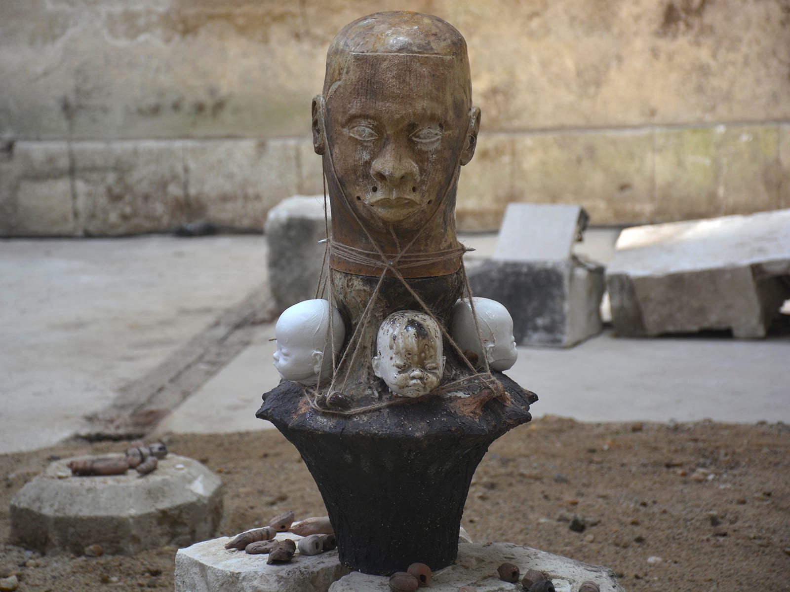 View of a sculpture showing a face on top of dolls head by Chada as part of his in-situ installation at Château de Montgoger featuring Rodolphe Blavy's collection