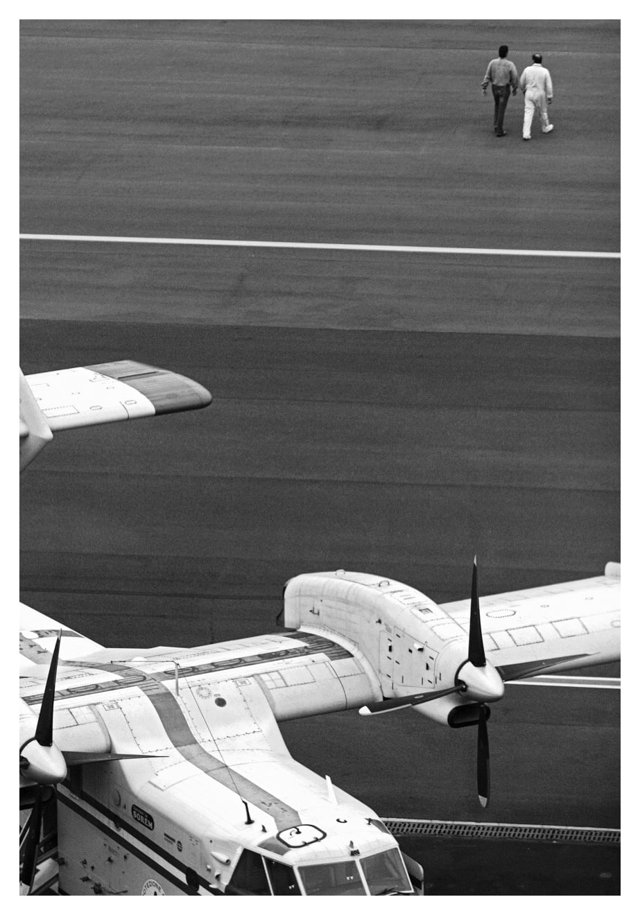Black and white photograph of two pilots at the Genova airport in Italy.