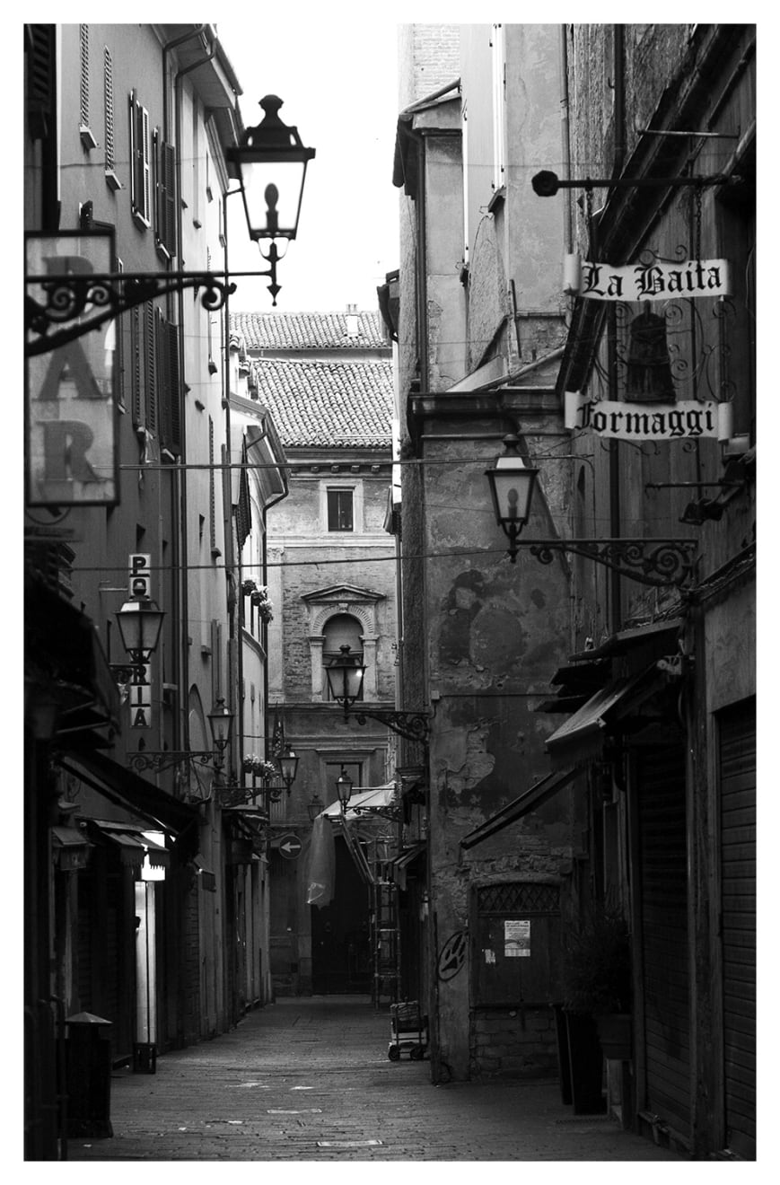 Black and white photograph of an empty street in Bologna Italy.