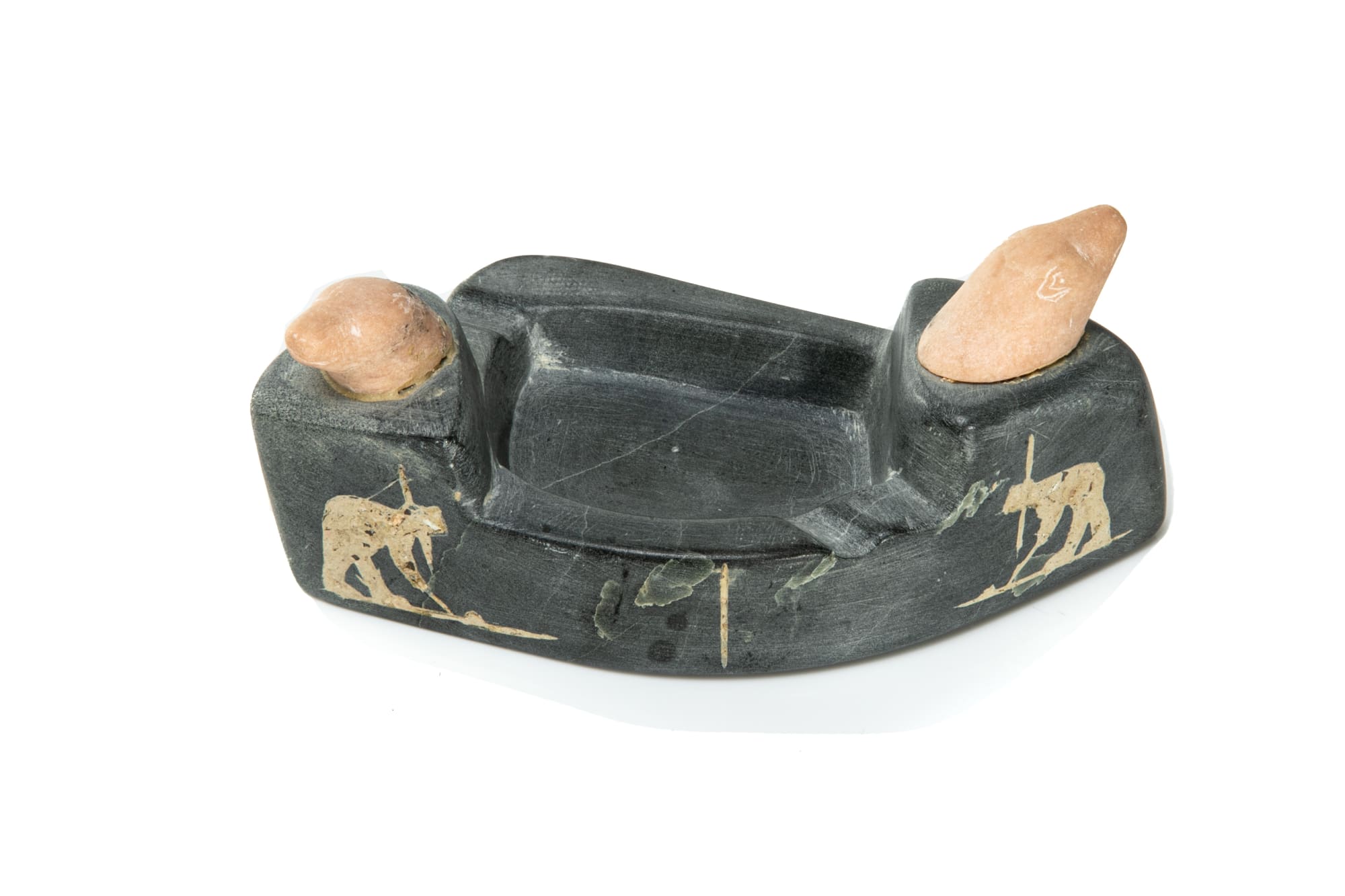 JOHNNY, KANGIQTUGAAPIK (CLYDE RIVER) Ashtray Decorated with Polar Bear Heads and inlaid Hunters in Kayaks, mid 1960s stone and inlay, 2.25 x 6.25 x 3.25 in (5.7 x 15.9 x 8.3 cm) $450