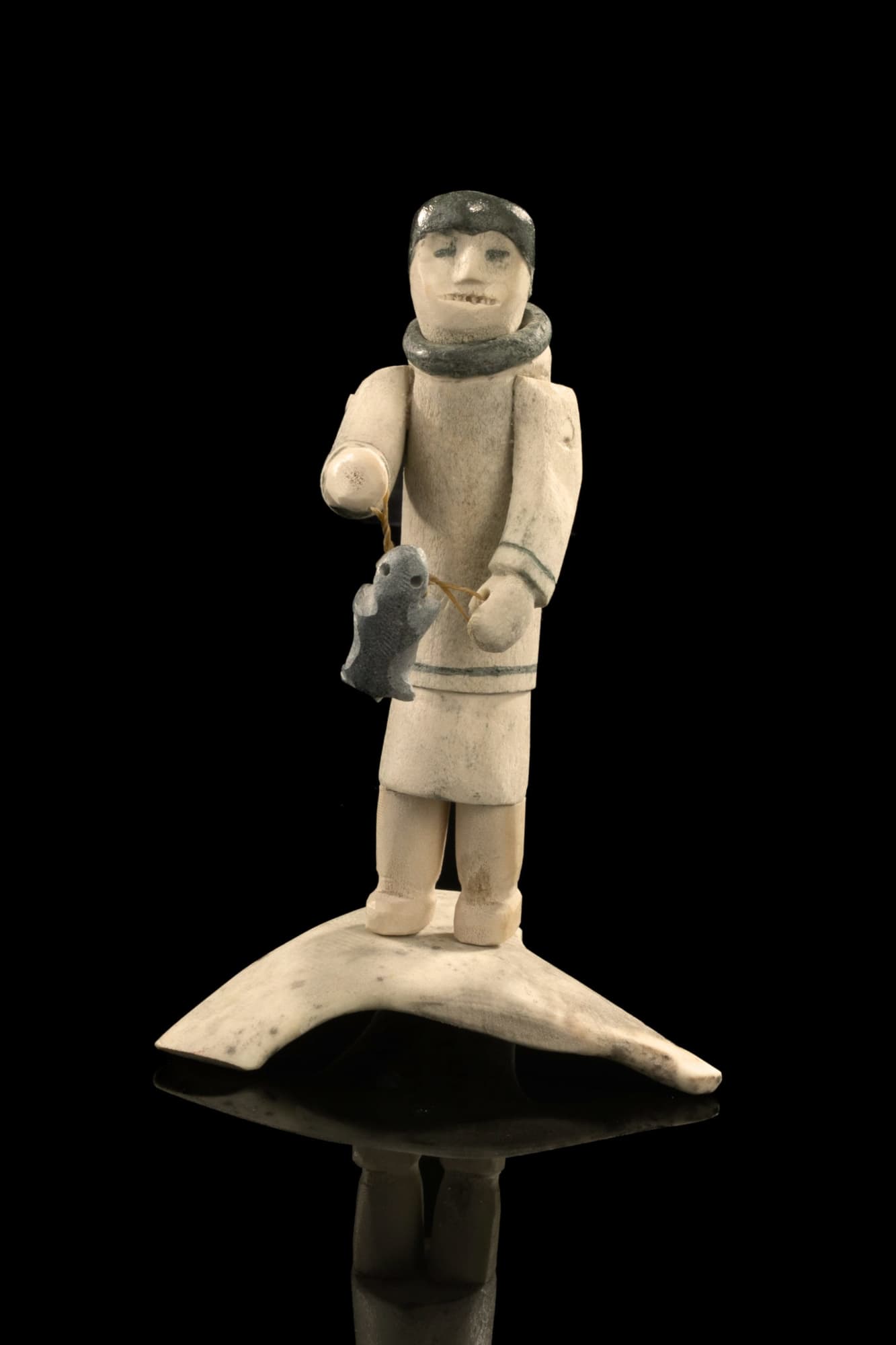 ROMEO EEKERKIK (1923-1983) ARVIAT (ESKIMO POINT) Man with Caught Lemming,, c. 1975 antler, pigment, stone, and sinew, 7.25 x 4.75 x 4.75 in (18.4 x 12.1 x 12.1 cm)