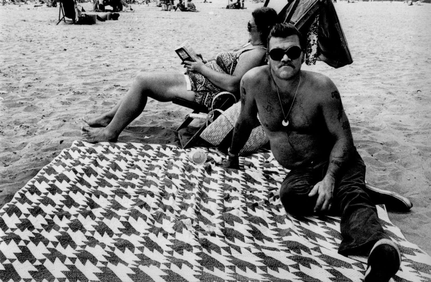 Arlene Gottfried Houndstooth Blanket on Coney Island Beach, New York Tirage gélatino-argentique d'époque sur papier Agfa Brovira, réalisé par l'artiste 22,7 x 14,7 cm Dim. papier: 27,7 x 35 cm