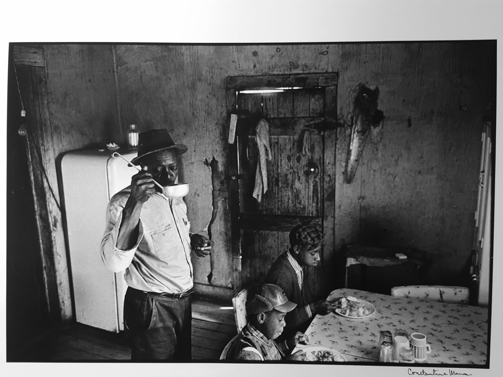 Constantine Manos, Untitled, Sharecroppers, South Carolina (interior, man drink from a ladle 2 children), 1965
