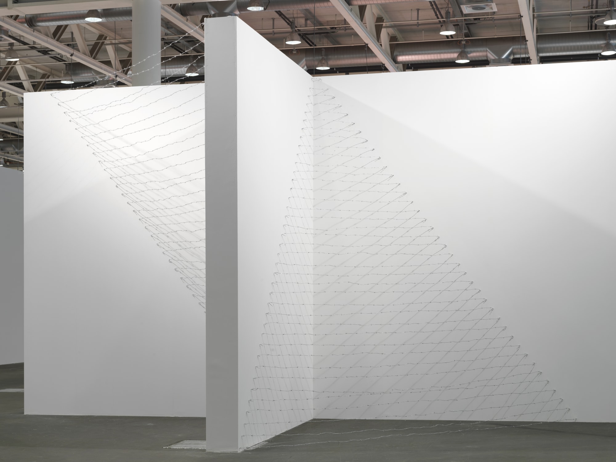 Installation view: Melvin Edwards: Pyramid Up and Down Pyramid ( (1969/2012), Barbed wire, dimensions variable, Alexander Gray Associates, Art Unlimited Art 43 Basel, 2012