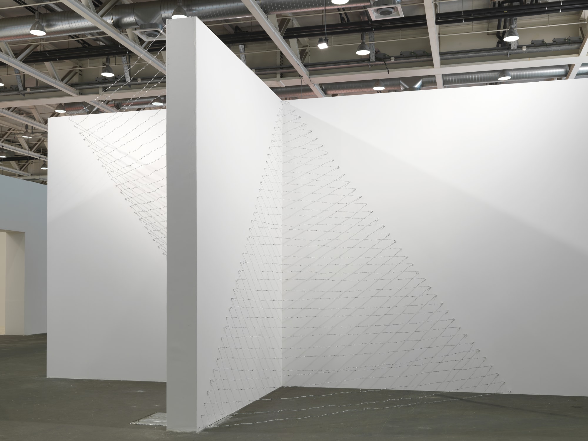 Installation view: Melvin Edwards: Pyramid Up and Down Pyramid ( (1969/2012), Barbed wire, dimensions variable, Alexander Gray Associates, Art Unlimited Art 43 Basel, 2012