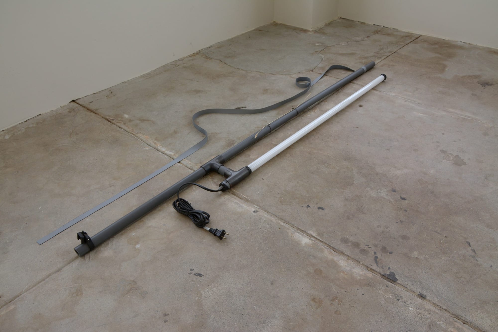 K.r.m. Mooney Joan Green, Bimetal I, 2014 Polyvinyl chloride conduit, copper union fittings, liver of sulfur, electrical splicing vinyl, cast lavender, silver, linear fluorescent, aquatic tank heating components, steel wire, bronzite bead 5 x 16 x 42 in 12.7 x 40.6 x 106.7 cm