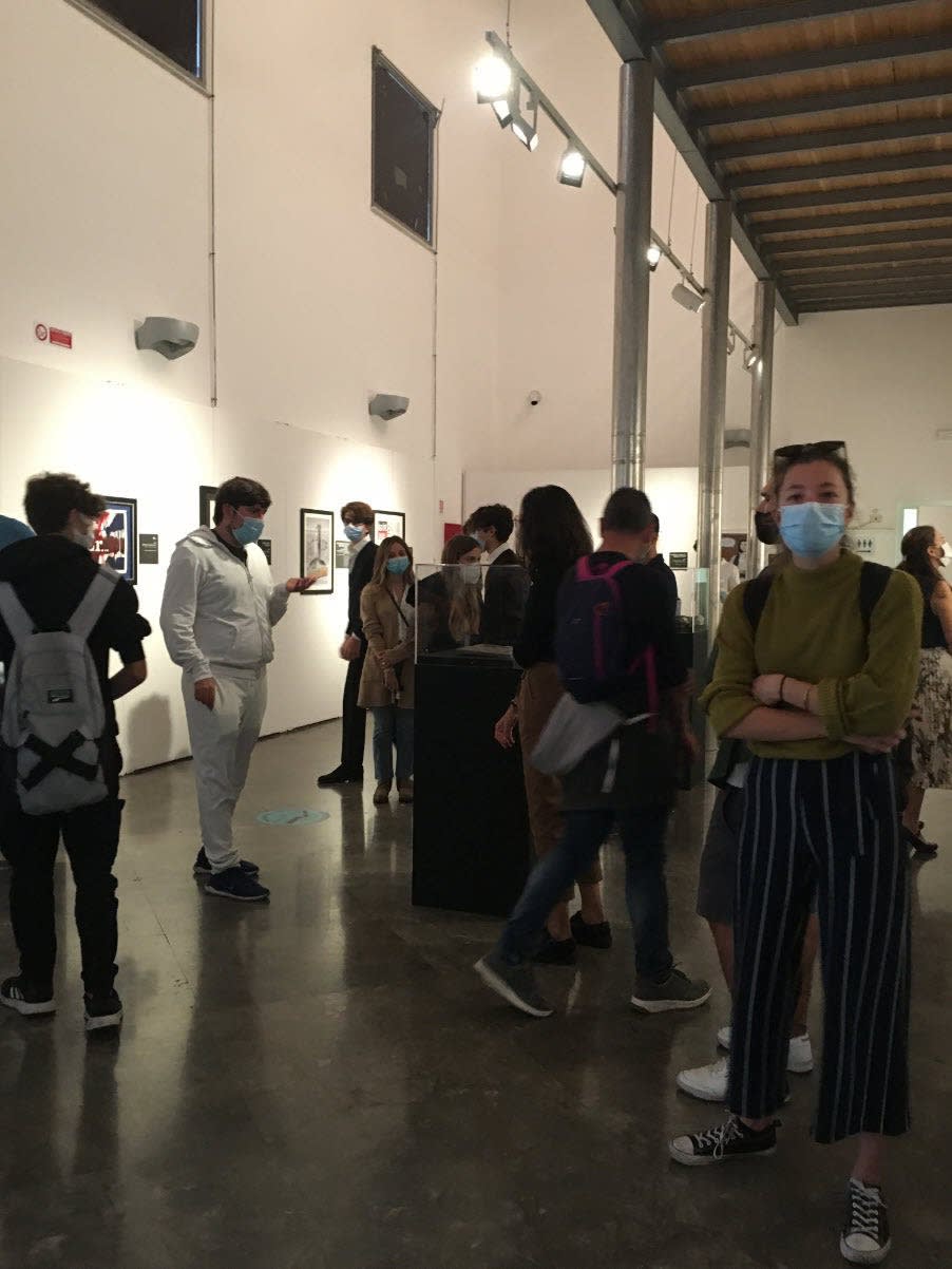 Banksy artworks on wall, people looking at the art